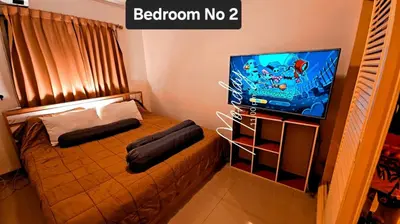 a small bedroom with a bed and a tv at River View Active 3 in Bangkok