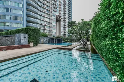 a swimming pool in front of a tall building at Watermark Chaophraya River Condo in Bangkok