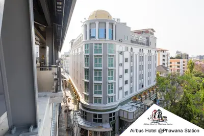 a white building with a gold dome on top of it at Airbus Hotel At Phawana Station in Bangkok