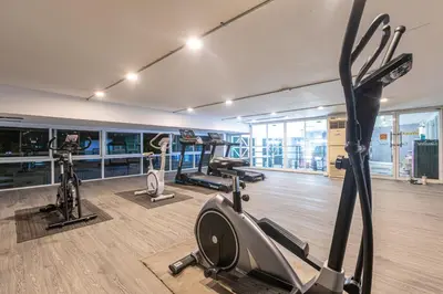 a gym with treadmills and ellipticals in a room at Airbus Hotel At Phawana Station in Bangkok