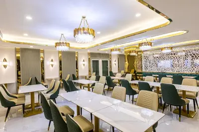 a restaurant with tables and chairs and chandeliers at Airbus Hotel At Phawana Station in Bangkok