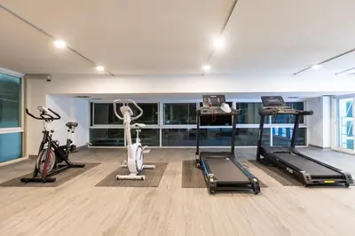 a gym with treadmills and exercise bikes in a room at Airbus Hotel At Phawana Station in Bangkok