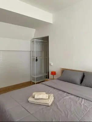a bedroom with a bed with two towels on it at J House in Nonthaburi