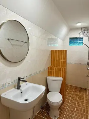 a bathroom with a sink and a toilet and a mirror at J House in Nonthaburi