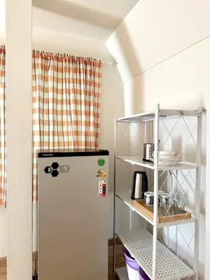 a kitchen with a refrigerator and a shelf at J House in Nonthaburi