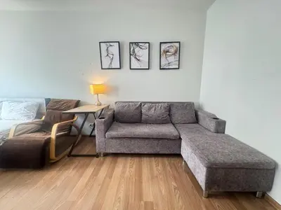 a living room with a couch and a bed at Sunlit Nest Sukhumvit in Ban Khlong Samrong