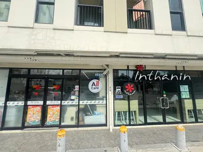 a store front of a building with signs on the windows at Sunlit Nest Sukhumvit in Ban Khlong Samrong