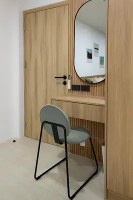 a chair in front of a door with a mirror at Peaceful Townhouse in Sathorn Near Saint Louis BTS in Yan Nawa