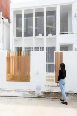 a woman standing in front of a white building at Peaceful Townhouse in Sathorn Near Saint Louis BTS in Yan Nawa