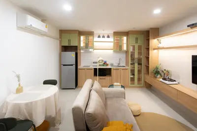 a kitchen and living room with a couch and a table at Peaceful Townhouse in Sathorn Near Saint Louis BTS in Yan Nawa
