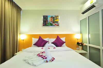 a bedroom with a bed with a swan on it at Premier Place Bangkok in Bangkok