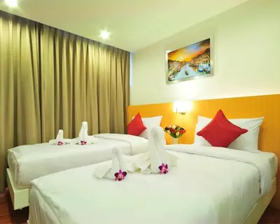 a hotel room with two beds with flowers on them at Premier Place Bangkok in Bangkok