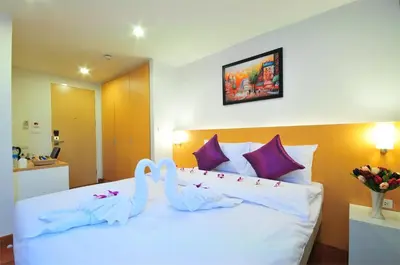 a bedroom with a bed with two swans on it at Premier Place Bangkok in Bangkok