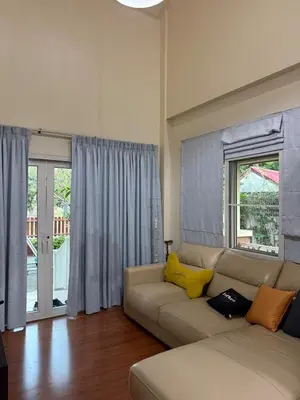 a living room with a white couch with yellow pillows at Family home Don muang airport in Lak Si