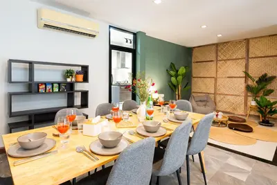 a dining room with a wooden table and chairs at 3BR design townhouse in central Bangkok - 10min to BTS, Emquartier in Bangkok