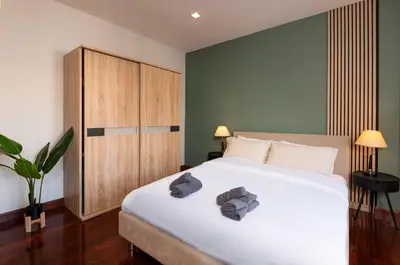 a bedroom with a bed with two towels on it at 3BR design townhouse in central Bangkok - 10min to BTS, Emquartier in Bangkok