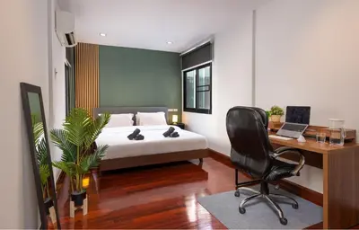 a bedroom with a bed and a desk and a chair at 3BR design townhouse in central Bangkok - 10min to BTS, Emquartier in Bangkok
