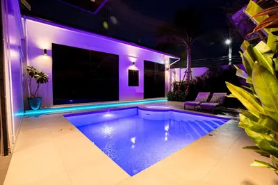 a swimming pool in a house with purple lighting at Bangkok Luxury Private Pool & Jacuzzi Villa , Daily Maid in Bang Bua Thong