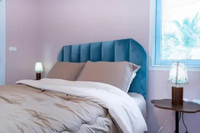 a bed with a blue headboard in a bedroom at Bangkok Luxury Private Pool & Jacuzzi Villa , Daily Maid in Bang Bua Thong