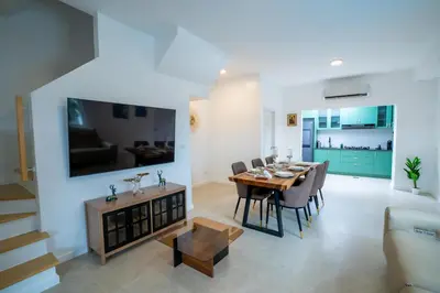 a dining room and living room with a table and chairs at Bangkok Luxury Private Pool & Jacuzzi Villa , Daily Maid in Bang Bua Thong