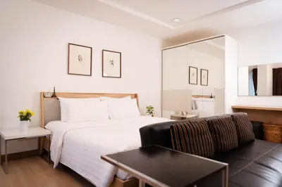a hotel room with a bed and a couch at Baan K Residence in Bangkok