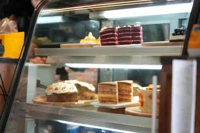 a display case with different types of cakes and desserts at Baan K Residence in Bangkok