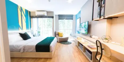a bedroom with a bed and a desk and a tv at Cozy apartment near Don Mueang airport in Lak Si