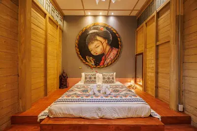 a bedroom with a bed with a painting on the wall at The Anonymous House in Bangkok