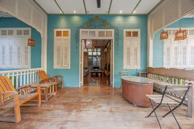 a room with blue walls and a tub and chairs at The Anonymous House in Bangkok