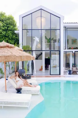 a woman sitting in a chair next to a swimming pool at Fira\u5e7d\u58837\u5367\u6cf3\u6c60\u8c6a\u534e\u522b\u5885 in Sathani Khlong Tan