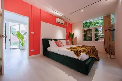 a bedroom with a bed and a red wall at Fira\u5e7d\u58837\u5367\u6cf3\u6c60\u8c6a\u534e\u522b\u5885 in Sathani Khlong Tan