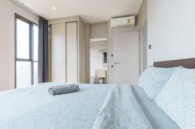 a bedroom with a bed with a pillow on it at Phetchaburi - Lumpini Condo in Bangkok