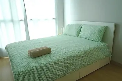 a bed in a bedroom with a pillow on it at Phetchaburi - Lumpini Condo in Bangkok
