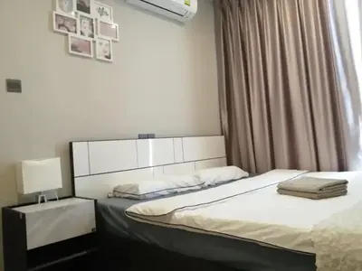 a bedroom with a bed and a window at Phetchaburi - Lumpini Condo in Bangkok