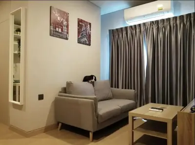 a living room with a couch and a table at Phetchaburi - Lumpini Condo in Bangkok