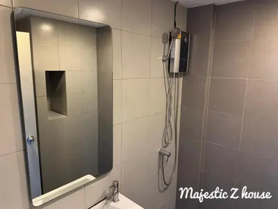 a shower with a mirror and a phone in a bathroom at Z house Sukhumvit in Bangkok