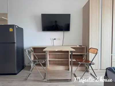 a table with two chairs and a television on a wall at Z house Sukhumvit in Bangkok