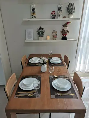 a wooden table with plates and wine glasses on it at PERFECT 80sqm apartment serve up to 5 \u5b8c\u7f8e\u7684\u516c\u5bd3 in Bangkok