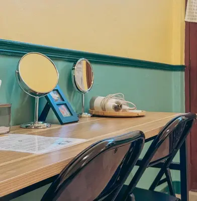 two mirrors sitting on a wooden counter with two chairs at During Moonshine Stay in Bangkok
