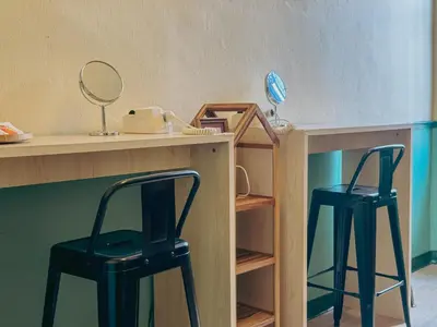 two black stools sitting under a desk with a mirror at During Moonshine Stay in Bangkok
