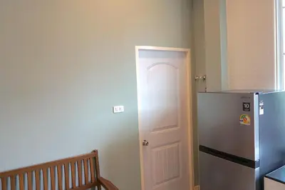 a kitchen with a refrigerator next to a door at Family Friendly Home in Bangna