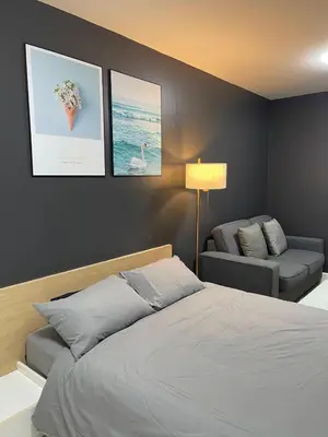 a bedroom with a bed and a couch and pictures on the wall at Studio123 at changwattana in Ban Bang Phang