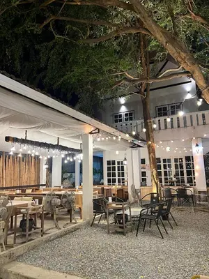 a restaurant with tables and chairs and a tree at Hotel Nanon Sathorn in Bangkok