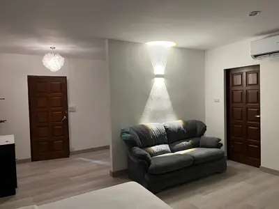 a living room with a couch and a light on the wall at Hotel Nanon Sathorn in Bangkok