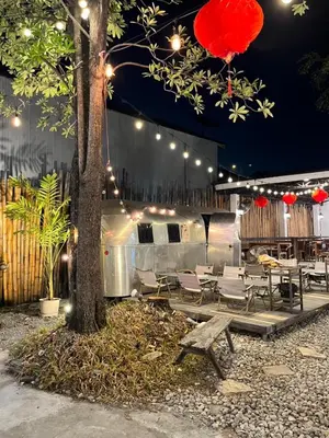 a patio with chairs and a tree with lights at Hotel Nanon Sathorn in Bangkok