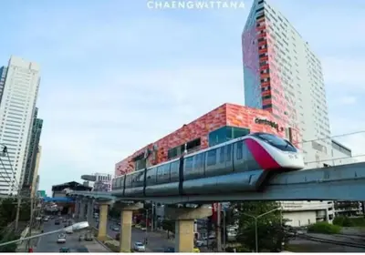 a train on a bridge in a city with buildings at Studio71 at changwattana in Ban Bang Phang