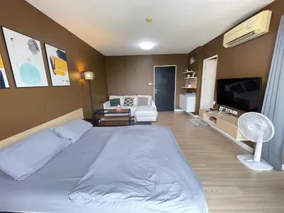 a bedroom with a large bed and a living room at Studio71 at changwattana in Ban Bang Phang