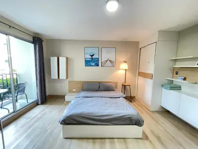 a bedroom with a bed and a large window at Studio16 at Changwattana in Ban Bang Phang