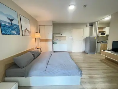 a small bedroom with a bed and a refrigerator at Studio16 at Changwattana in Ban Bang Phang