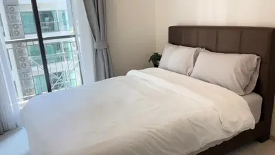 a bed with white sheets and a large window at Luxurious Downtown Apartment With Train Access Bts in Bangkok
